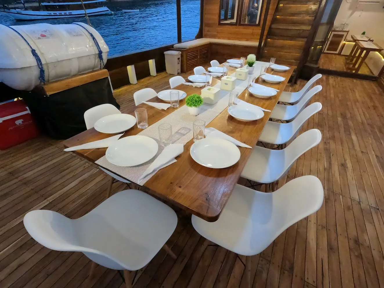 Open-air dining table on the main deck of a charter yacht