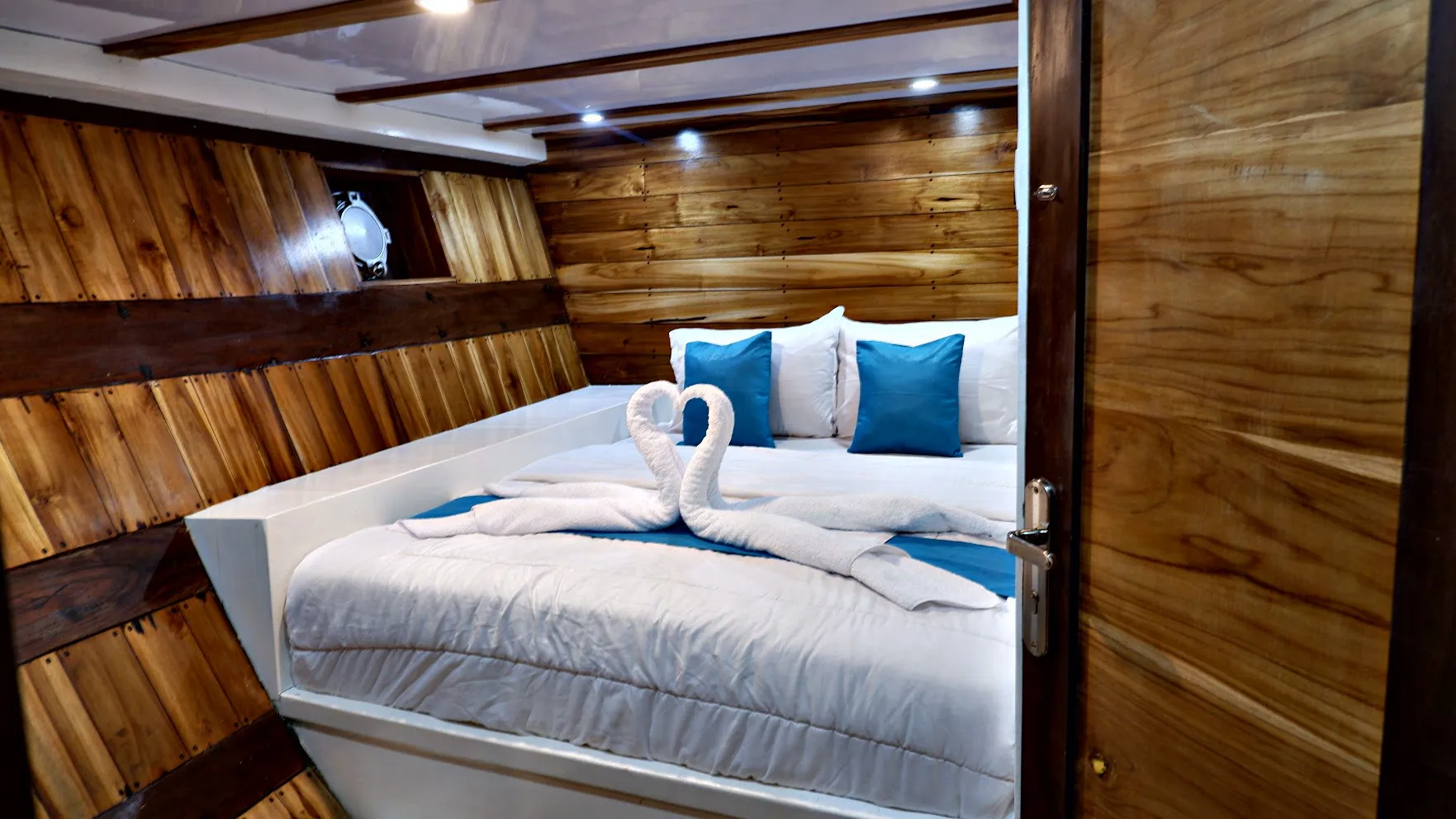 Guest cabin finished in polished teak with fresh linen