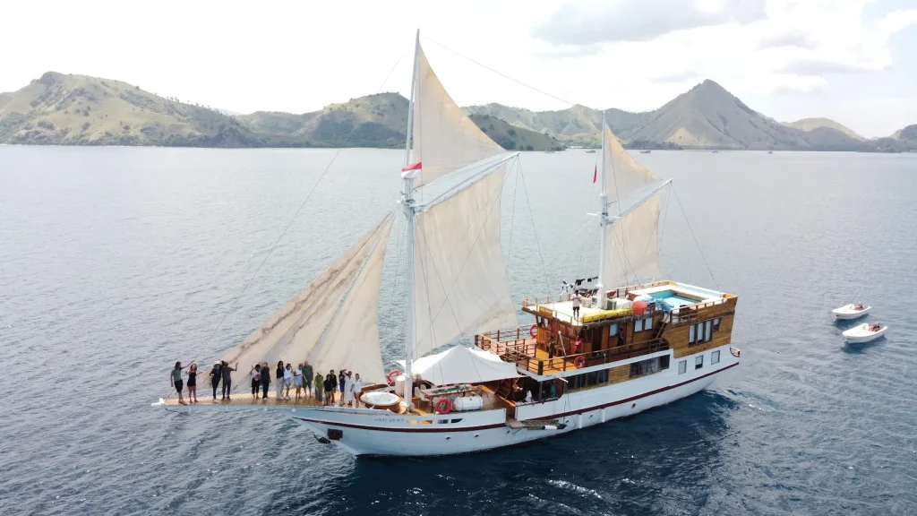 Guests on the deck of a phinisi at anchor