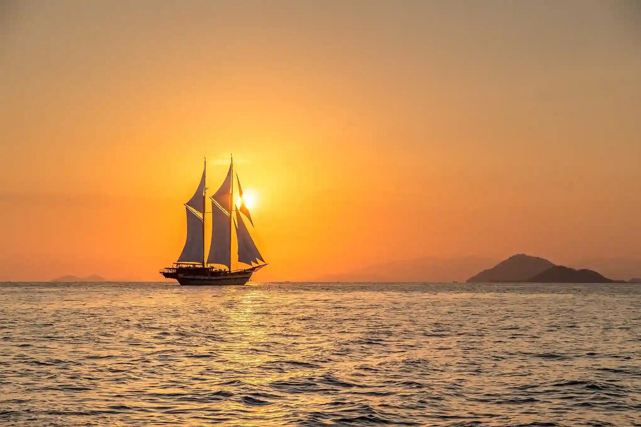 Phinisi sailing at sunset in Komodo waters
