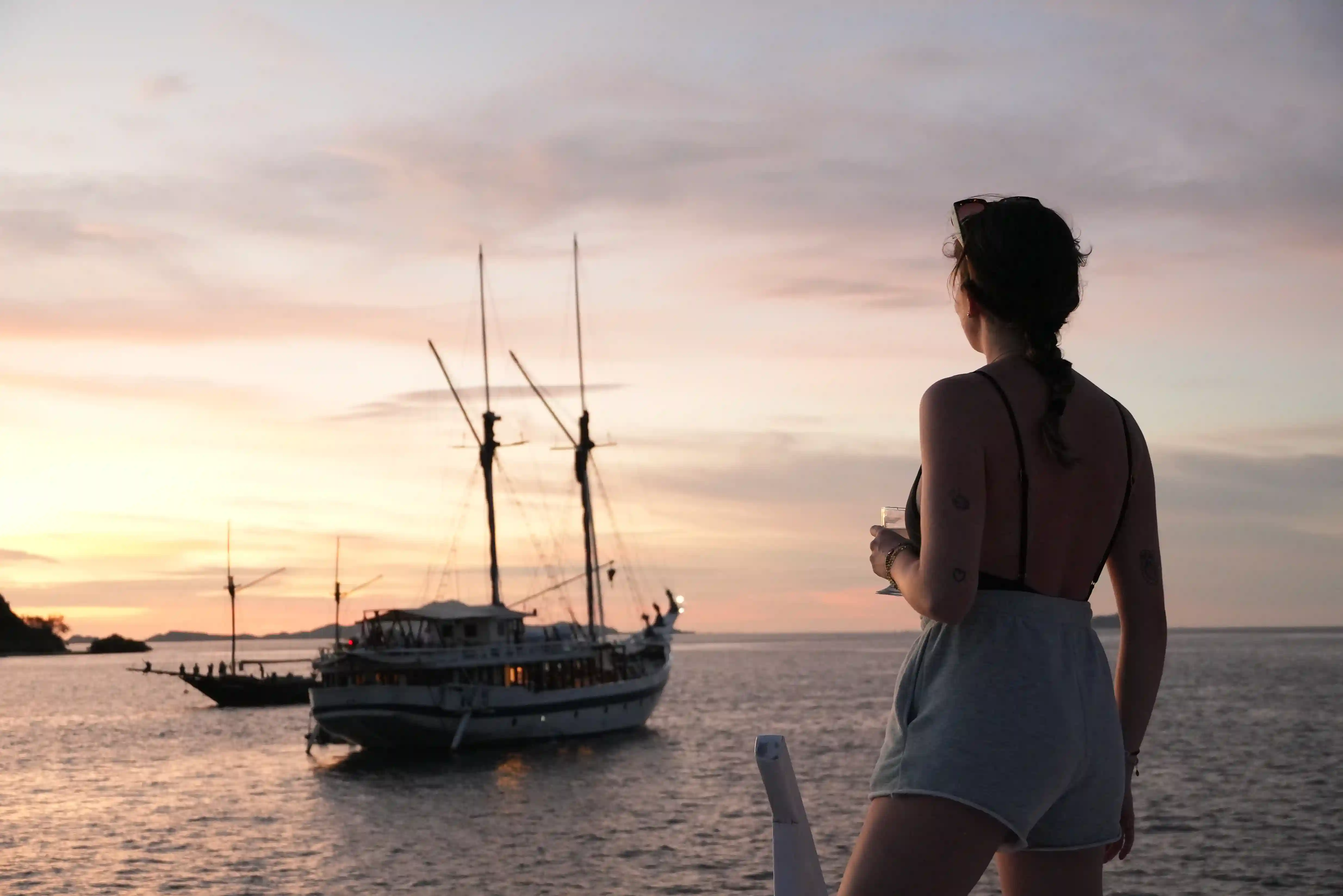 Phinisi silhouetted at sunset off Kalong Island
